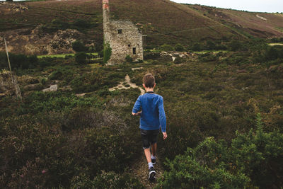 Rear view of boy walking on mountain