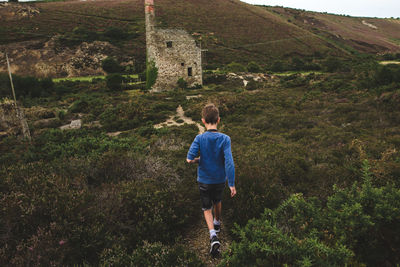 Rear view of boy walking on mountain