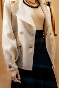 Fancy details of a classic white jacket with golden buttons and black skirt. women's fashion