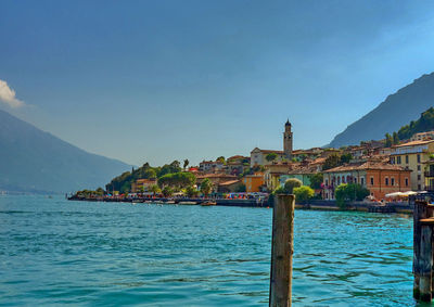 Sea by buildings against sky