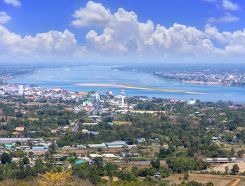 High angle view of townscape by sea against sky