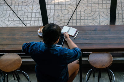 Rear view of man using mobile phone