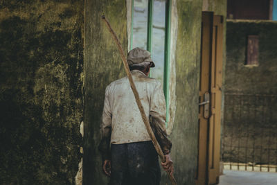 Rear view of man walking against wall