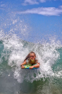 Young woman surfboarding in sea wave