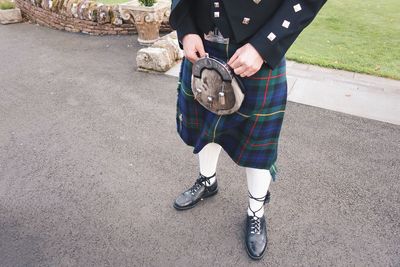 Low section of man standing on road