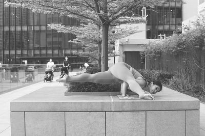 Side view of woman walking by swimming pool in city