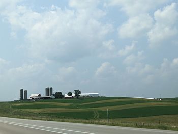 Road amidst field against sky