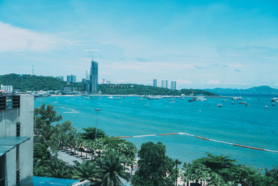 High angle view of city by sea against sky