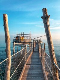 Wooden pier over sea against sky