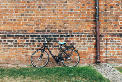 Bicycle leaning against brick wall