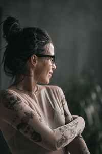 Young woman looking away while sitting outdoors