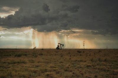 Man on field against sky during sunset