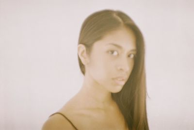 Close-up portrait of young woman over white background