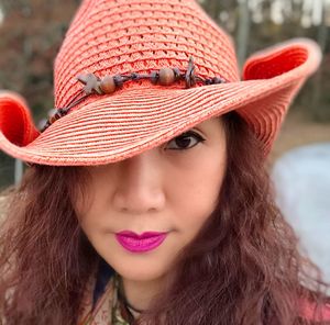 Close-up portrait of smiling young woman wearing hat