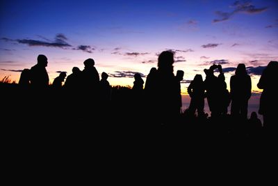 Silhouette of people against sky during sunset