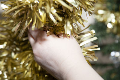 Close-up of hand holding tinsel