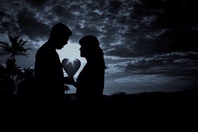 Silhouette couple standing against sky