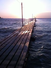 Pier on sea at sunset