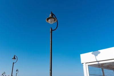 Low angle view of street light against clear blue sky