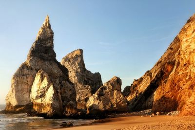 Rock formations in sea against sky