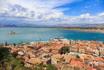 High angle view of townscape by sea against sky