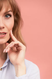 Portrait of young woman against yellow background