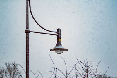 Low angle view of street light against sky during winter