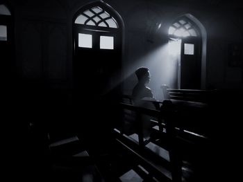 Man sitting on bench in darkroom