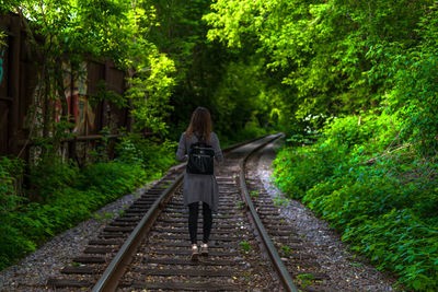 Rear view of woman on railroad tracks