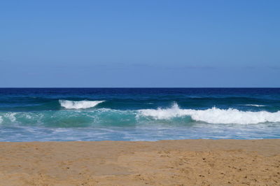 Scenic view of sea against clear blue sky