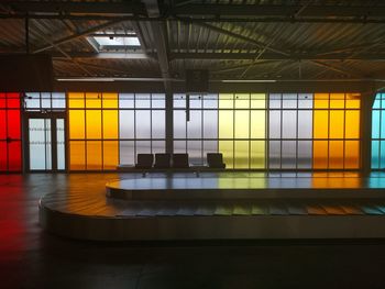 Conveyor belt against colorful windows at airport