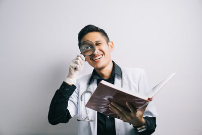 Young woman using mobile phone against white background