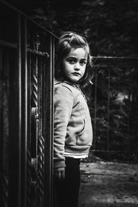 Side view portrait of girl standing against railing