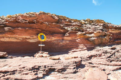 Road sign on mountain against sky