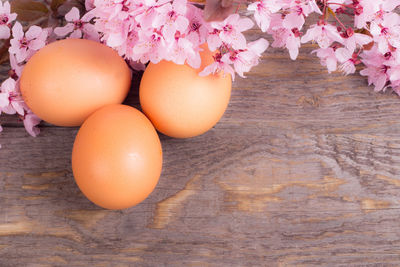 Close-up of easter eggs and flowers on wood