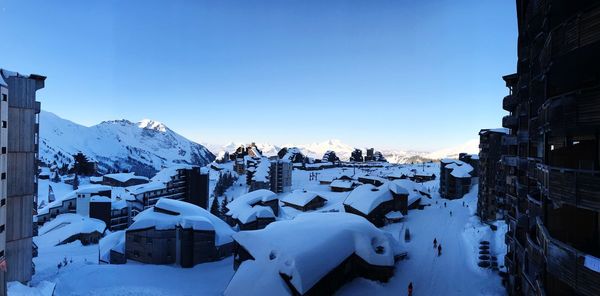 Panoramic view of snow covered mountains against clear blue sky