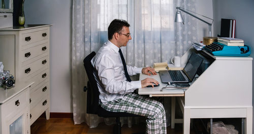 Rear view of man working on table