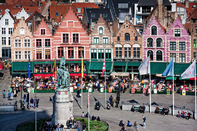 People on street against buildings in city