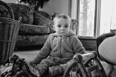 Portrait of cute girl sitting on floor at home