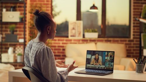 Rear view of woman using laptop at office