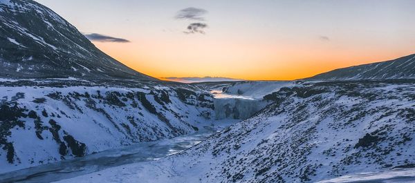 Scenic view of snow covered mountains against sky during sunset