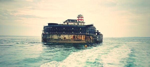 Built structure in sea against sky