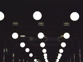 Low angle view of illuminated light bulbs hanging from ceiling