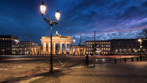 Illuminated brandenburg against cloudy sky at night