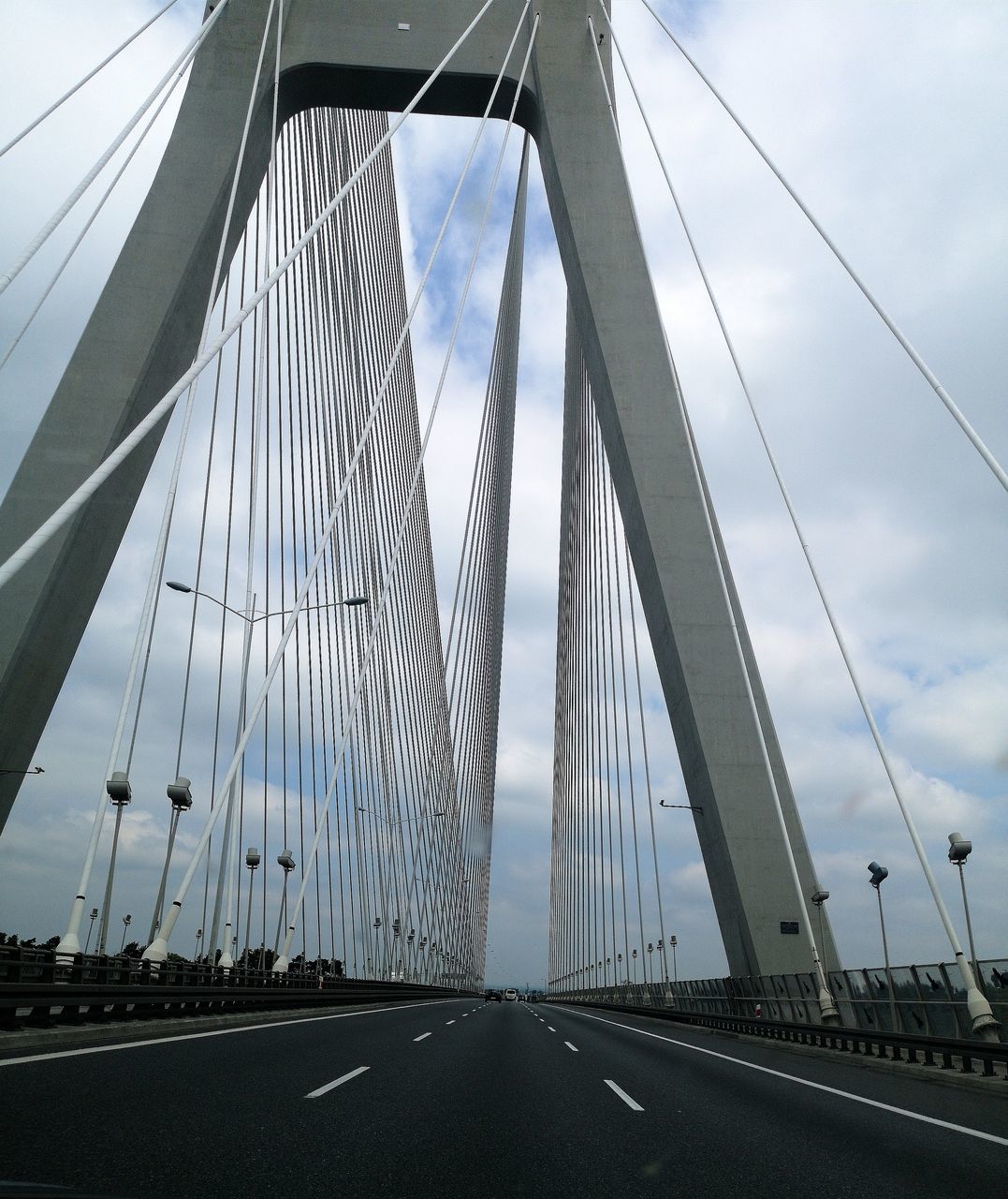 transportation, connection, engineering, bridge, bridge - man made structure, road, suspension bridge, direction, the way forward, sky, architecture, cable-stayed bridge, built structure, cloud - sky, nature, motor vehicle, steel cable, car, cable, diminishing perspective, outdoors, modern, long