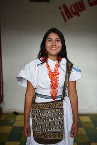 Portrait of happy young arhuaco indigenous woman in a urban environment, colombia