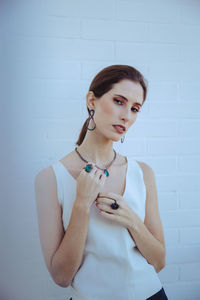 Portrait of woman standing against wall