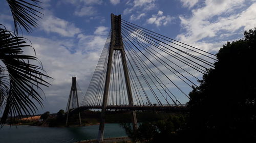 Low angle view of suspension bridge against sky