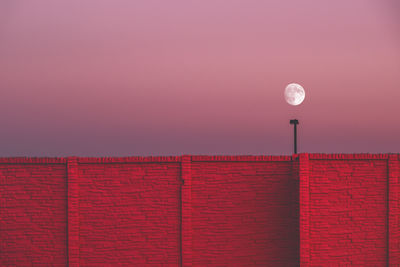 Low angle view of red light against sky at sunset