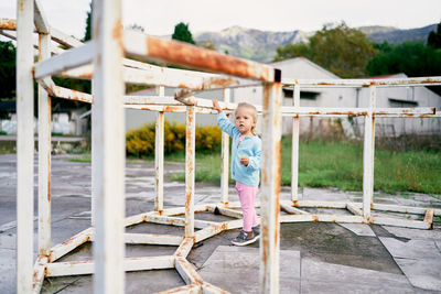 Rear view of woman standing by fence